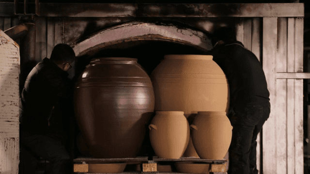 두 사람이 가마에 도자기를 넣는 모습