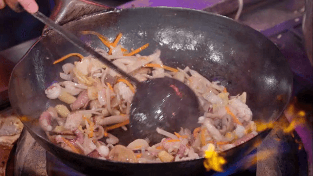 Stir-frying vegetables and seafood in a hot wok