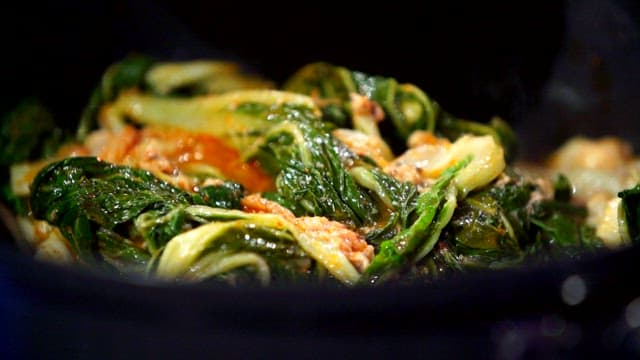 Putting seasoning broth in a pot with napa cabbage