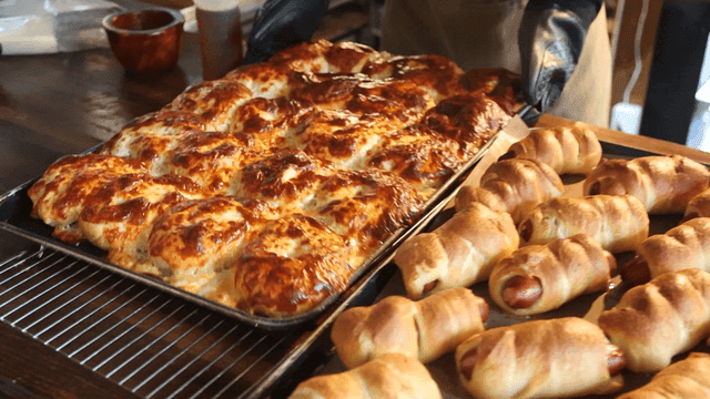 갓 구운 콰트로치즈 베이글을 오븐에서 꺼내는 제빵사