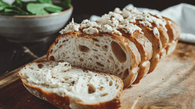 Cream-topped ciabatta on cutting board