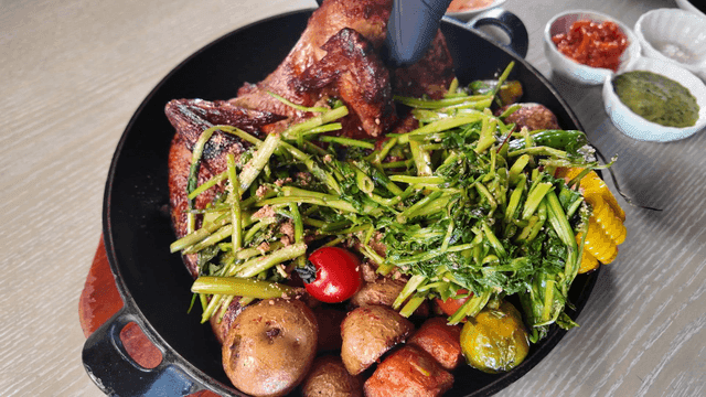 Hand picking up grilled chicken topped with water parsley