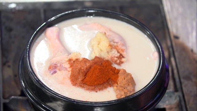 국자로 양념과 섞는 오리탕