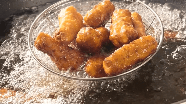 Golden fried chicken sizzling in hot oil