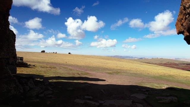 Rock Arch in the Middle of a Meadow under a Blue Sky