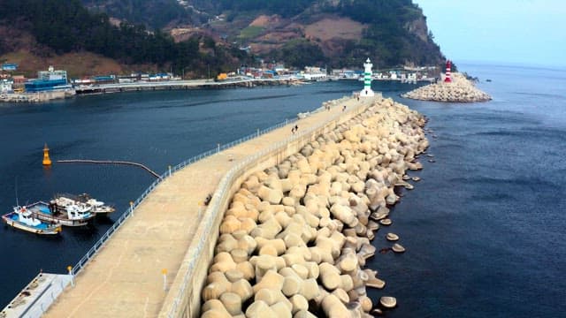 Two lights at the end of a pier with mountains in the background