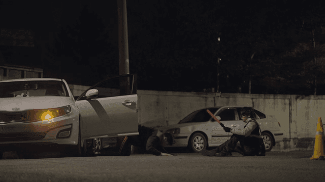 Man crawling out of a car and a startled patrol officer