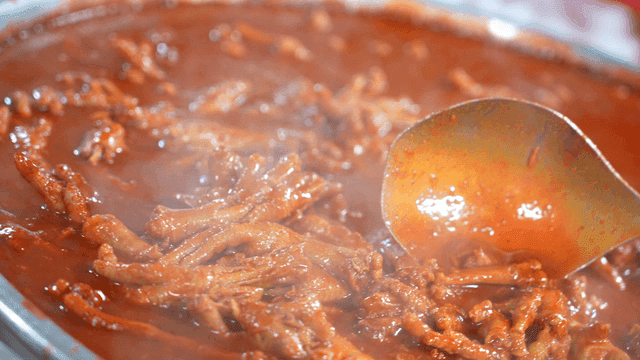 Spicy chicken feet boiling in sauce