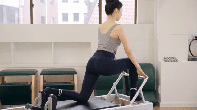 Woman practicing pilates on a reformer