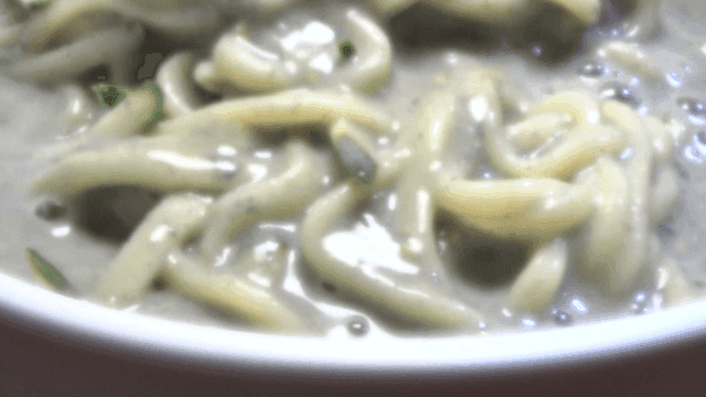 콩가루가 뿌려진 콩국수가 젓가락으로 섞이는 장면