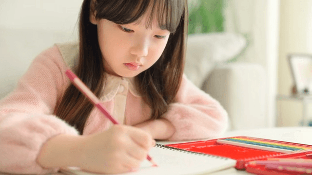 Young girl focused on drawing indoors