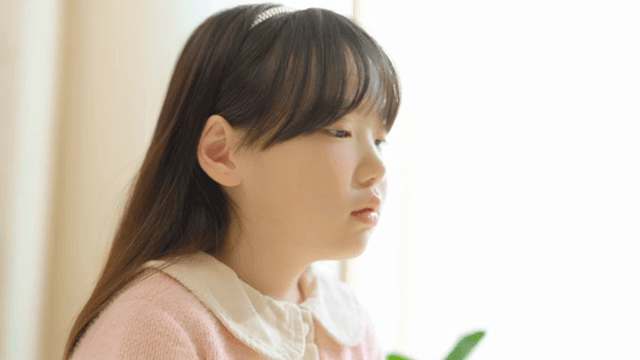 한숨을 쉬는 분홍 스웨터를 입은 어린 소녀