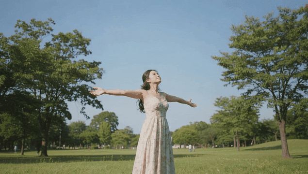 공원 잔디밭에서 햇살을 즐기는 젊은 여성