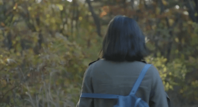 산 속을 빠르게 걷는 여성의 뒷모습