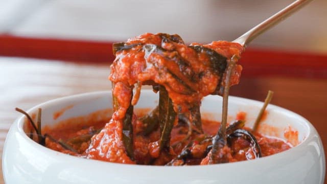 사발에 담긴 새콤달콤한 즙장을 숟가락으로 뜨는 모습