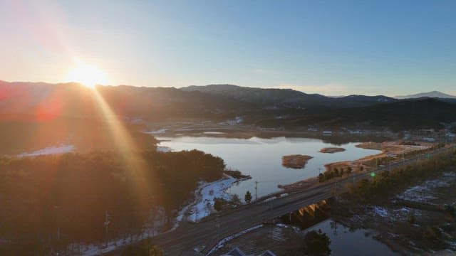 Sunrise over a serene lake and mountains