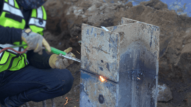 건설 현장에서 금속 빔을 용접하는 작업자