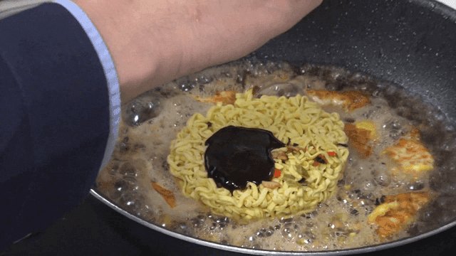 Sauce poured in oily pan over ramen
