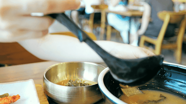 국자로 그릇에 시래기 된장국을 국자로 떠내는 사람