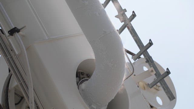 증기를 뿜는 서리가 낀 산업용 파이프의 모습