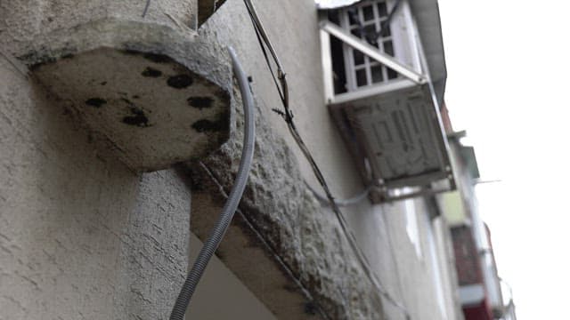 비 오는 날에 오래된 에어컨과 케이블이 있는 외벽