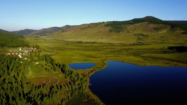 Vast green landscape with a calm lake