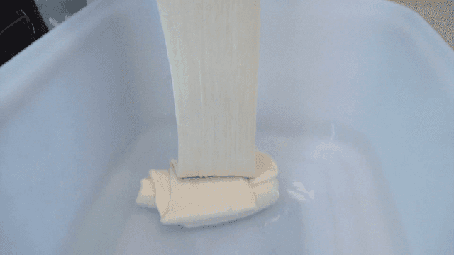 Pouring elastic dough into mixing bowl