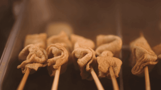 Fish cake skewers steaming in a pot