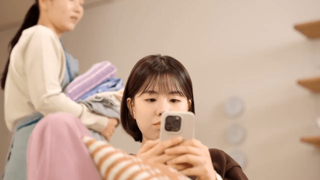 Mother looking at her daughter using her smartphone with pitiful expression.