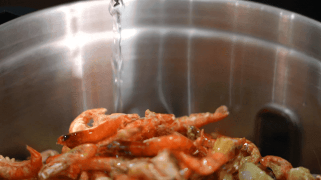 Soju poured over shrimp in pot