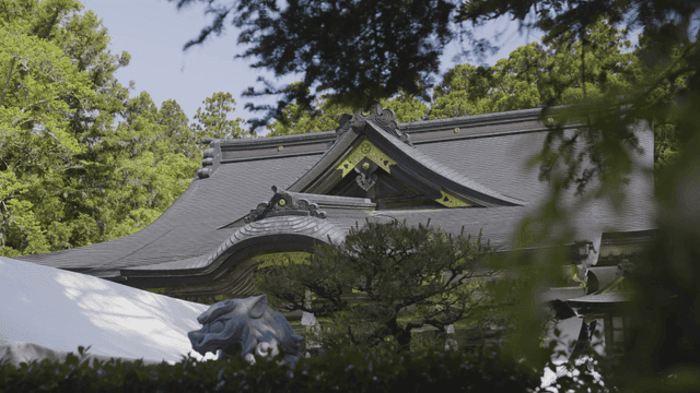 Traditional Japanese temple surrounded by green trees