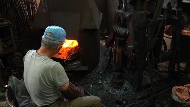 Craftsman forging a heated metal blade