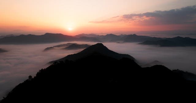 Sky Colored by Sunrise over Foggy Mountains