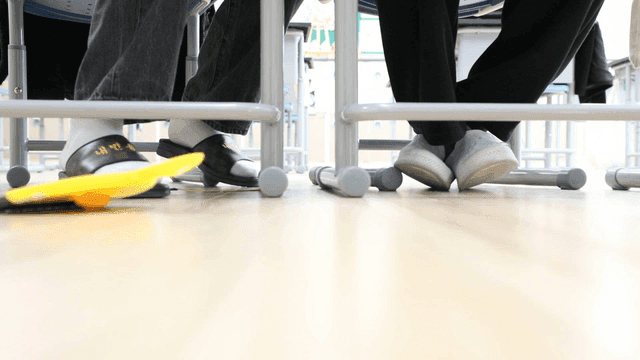 Elementary school students' feet under classroom desks