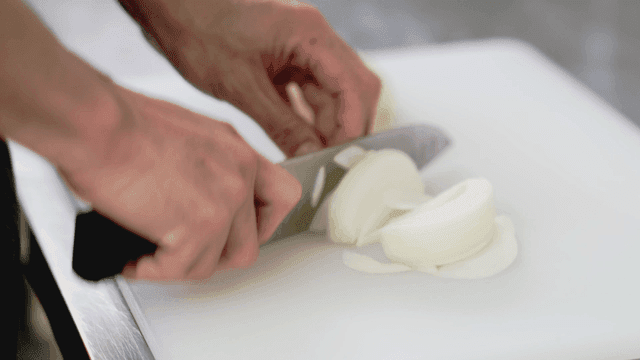 도마 위에서 양파를 써는 모습