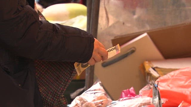 시장 상점에서 상품 값을 지불하는 고객