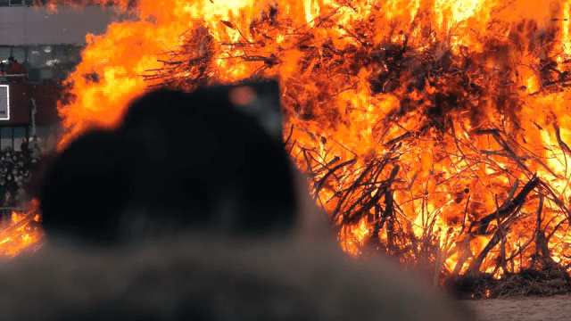 Large bonfire with a crowd watching