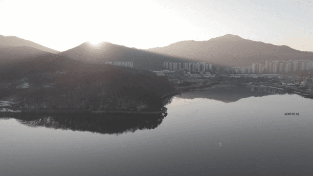 산과 도시 풍경 위로 떠오르는 해