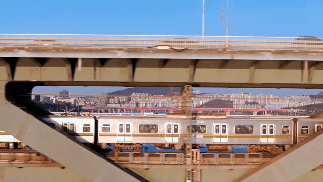 Train passing under a bridge in the city