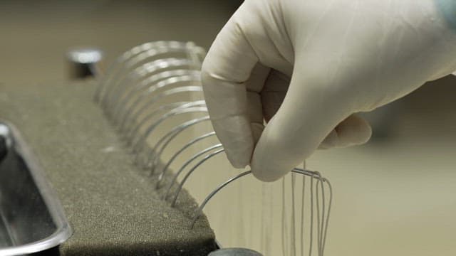 수술용 와이어를 다루는 장갑 낀 손