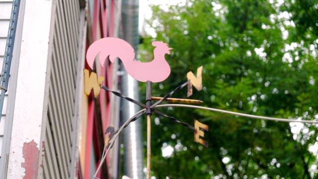 건물 위의 빨간색 수탉 풍향계