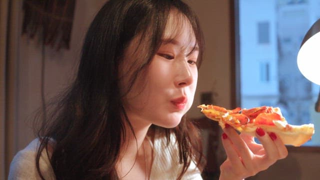 여자가 실내에서 피자를 즐기는 모습
