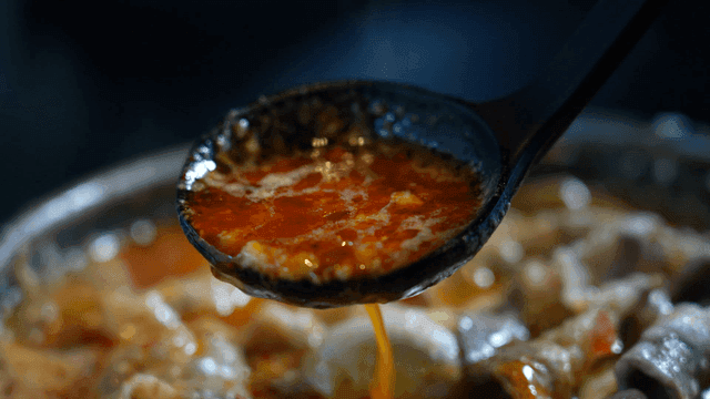 Ladle lifting cheese mala hot pot