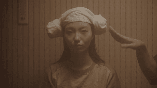 사우나에서 수건을 머리에 두른 사람