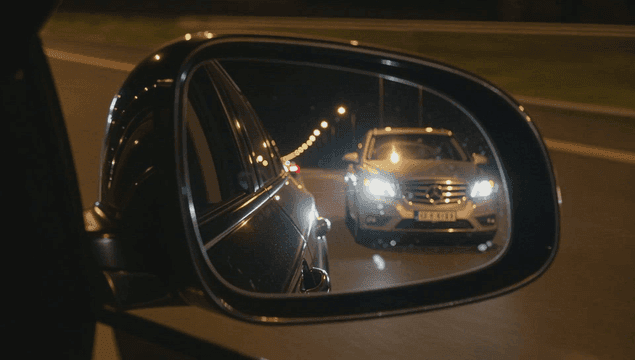 야간 도로에서 사이드 미러로 비치는 밤에 가까이 따라오는 차