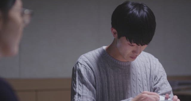 종이 봉투를 급하게 열어보는 남자