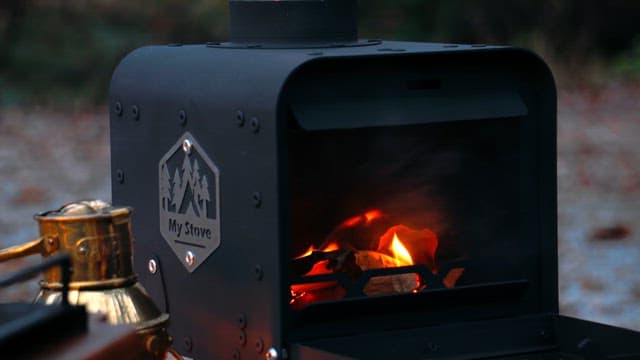 Firewood Being Thrown into a Campfire Stove