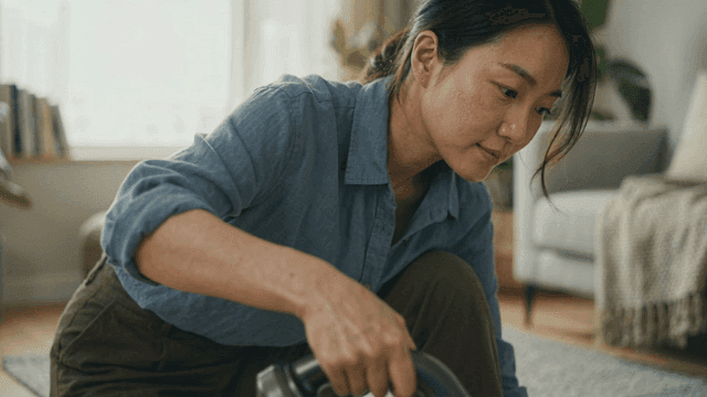 Woman vacuuming in living room.