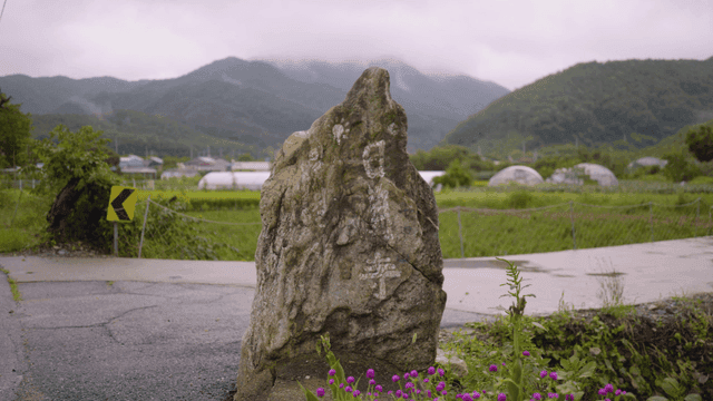Country road with stone marker and mountain
