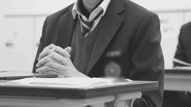 책상에 앉아 있는 교복 입은 학생